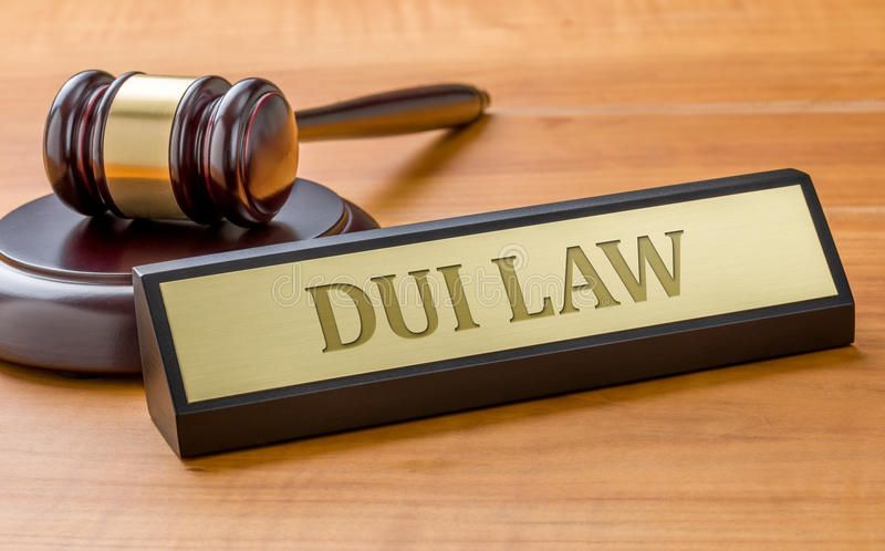 A gavel and a nameplate reading 'DUI LAW' on a wooden desk.